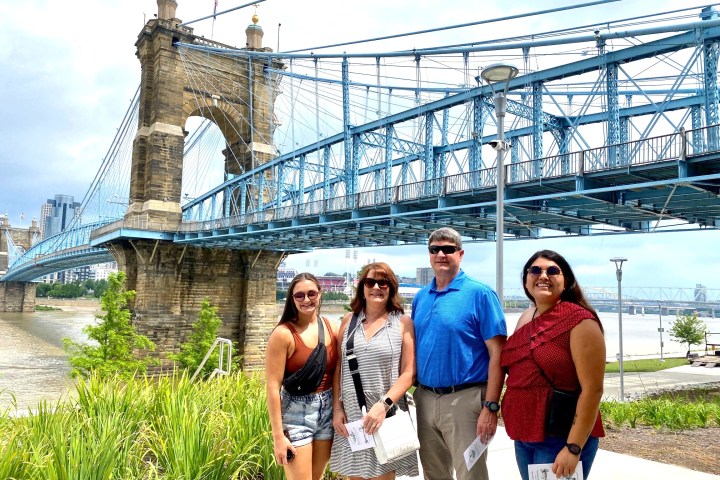 a group of people standing in front of a bridge